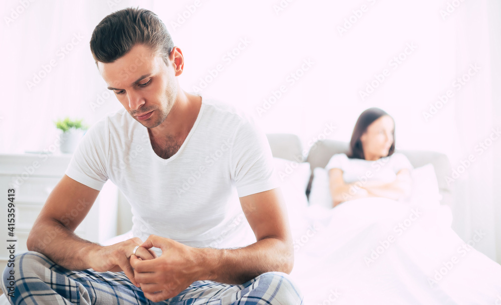 Young unhappy married couple in bedroom. Serious quarrel in family during covid-19 quarantine Young unhappy married couple in bedroom. Serious quarrel in family during covid-19 quarantine