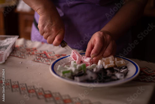 housewife slicing Turkish delicacies into small cubes on a plate