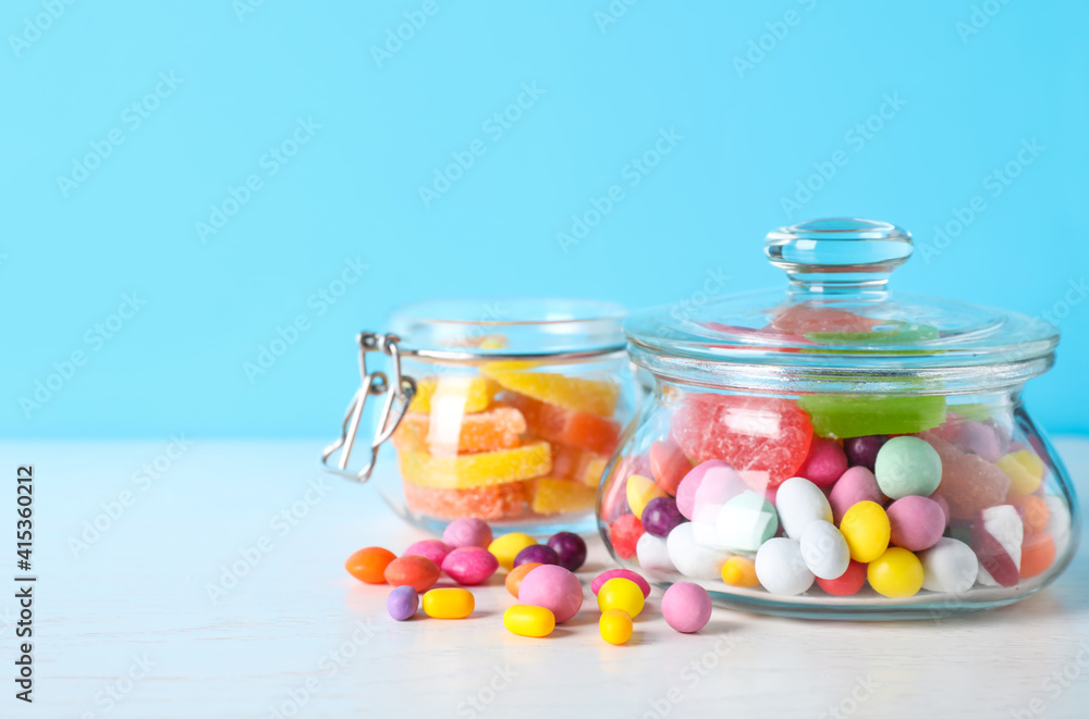 Different yummy candies on light blue background. Space for text Different yummy candies on light blue background. Space for text
