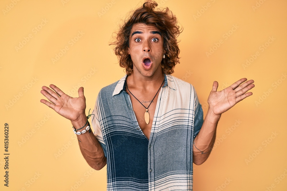 Young hispanic man wearing summer style celebrating victory with happy smile and winner expression with raised hands