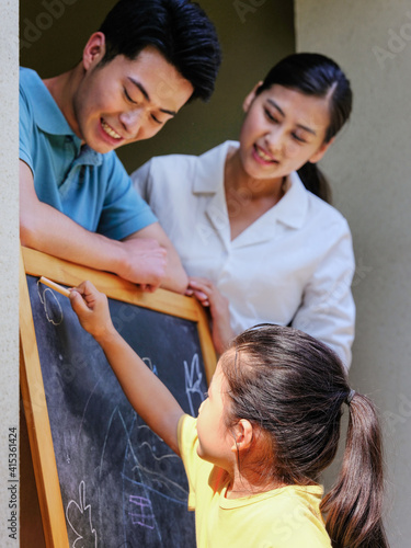 Happy family of three painting outdoors