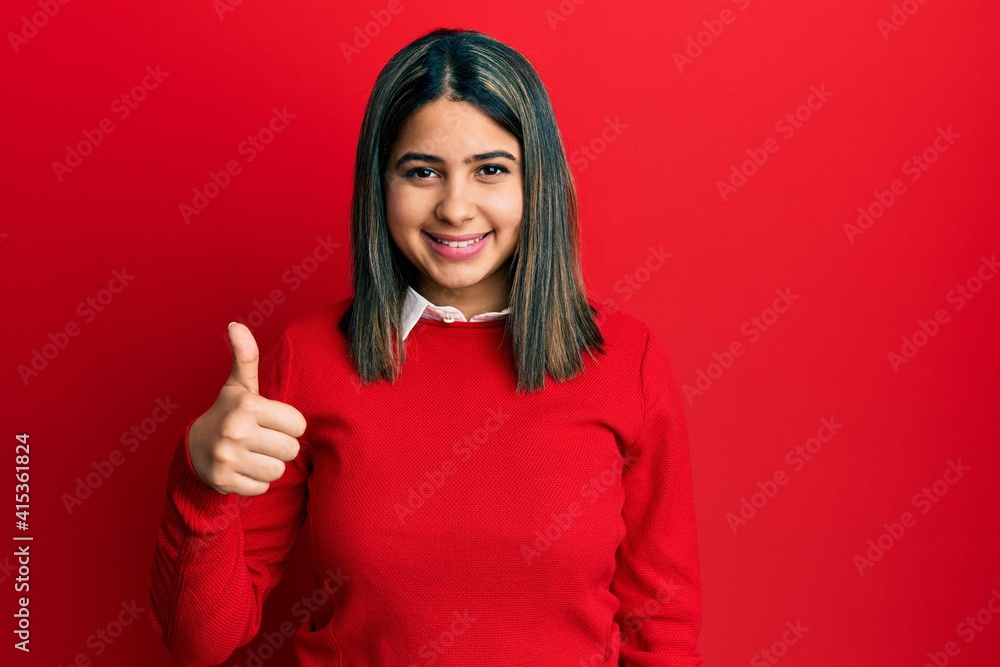 Young latin woman wearing casual clothes doing happy thumbs up gesture with hand. approving expression looking at the camera showing success. Young latin woman wearing casual clothes doing happy thumbs up gesture with hand. approving expression looking at the camera showing success.