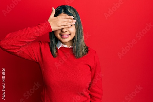 Young latin woman wearing casual clothes smiling and laughing with hand on face covering eyes for surprise. blind concept. © Krakenimages.com