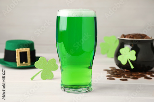 Green beer and St Patrick's Day decor on white wooden table