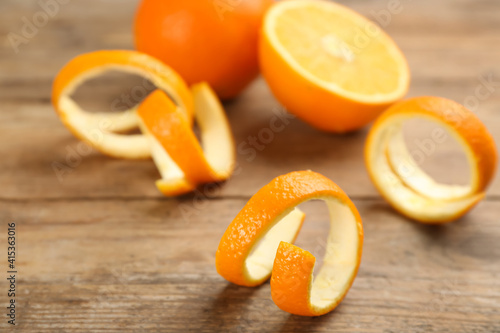 Foto Fresh spiral orange peels on wooden table
