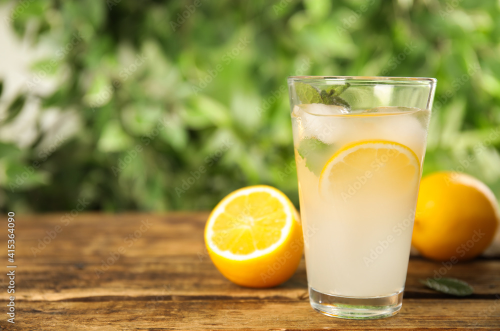 Cool freshly made lemonade in glass on wooden table. Space for text Cool freshly made lemonade in glass on wooden table. Space for text