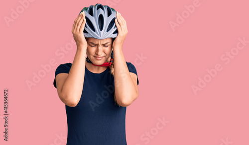 Fotografie Beautiful caucasian woman wearing bike helmet suffering from headache desperate and stressed because pain and migraine