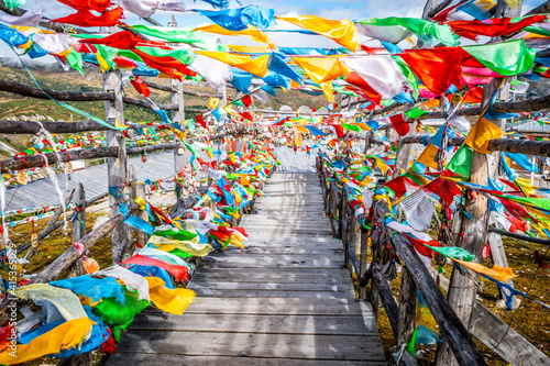 Alley of Tibetan prayer flags and wooden prayer cards at Shika snow mountain in Yunnan China photo