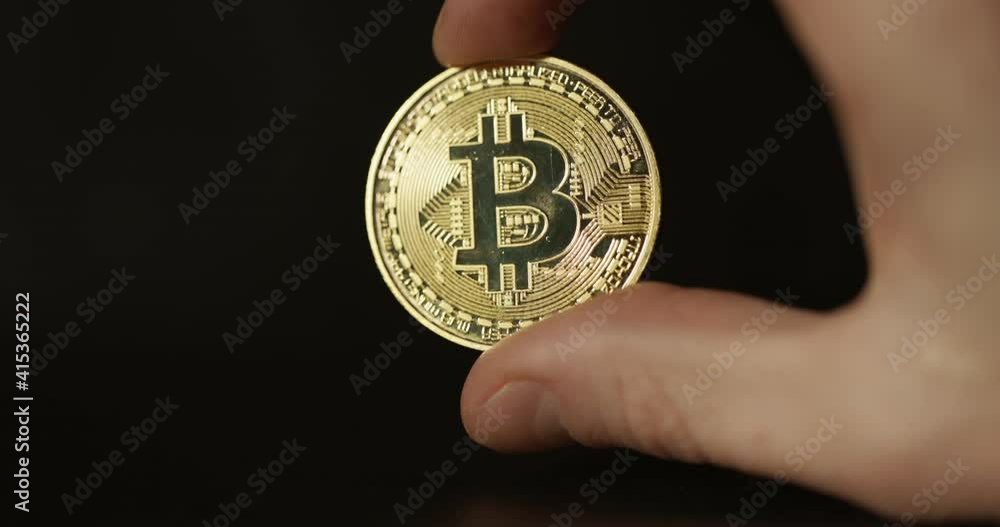 Shiny physical bitcoin in hands over sunlight Shiny physical bitcoin in hands over sunlight