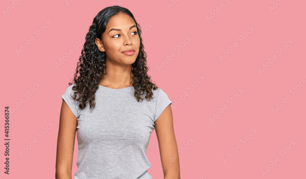 Young african american girl wearing casual clothes smiling looking to the side and staring away thinking. Young african american girl wearing casual clothes smiling looking to the side and staring away thinking.