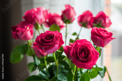 Beautiful flower bouquet of pink rose. Big bouquet of roses in vase on table near the window.
