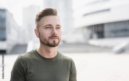 Handsome serious young man portrait, Cheerful casual student men looking away on a city street.