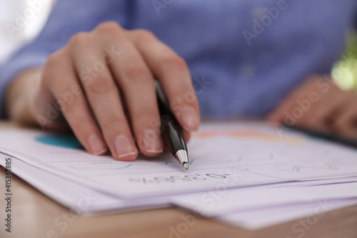 Businesswoman working with documents at table in office, closeup. Investment analysis