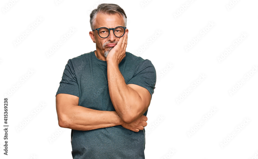 Middle age grey-haired man wearing casual clothes and glasses thinking looking tired and bored with depression problems with crossed arms. Middle age grey-haired man wearing casual clothes and glasses thinking looking tired and bored with depression problems with crossed arms.