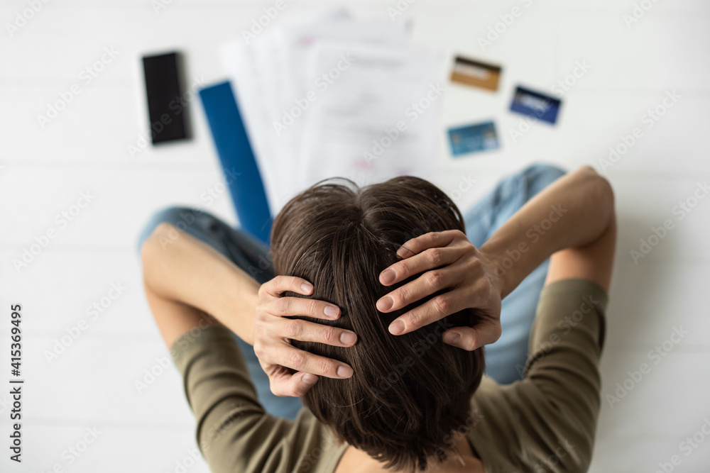 Fototapeta premium Exhausted stressed woman looking at bills. Calculating family budget, crisis, finance, spending money concept