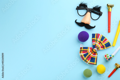 Flat lay composition with clown accessories on light blue background. Space for text