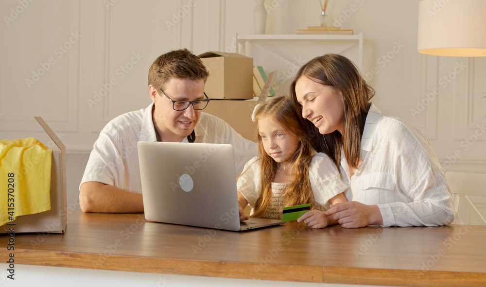 A Happy Family Uses a Laptop for Online Shopping, Sitting at Home. A Happy Family Uses a Laptop for Online Shopping, Sitting at Home.
