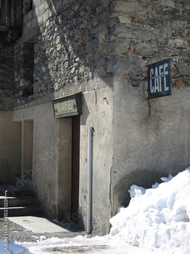 Fototapeta Naklejka Na Ścianę i Meble -  Abandoned cafe in French alpine village and snow piled up in the street