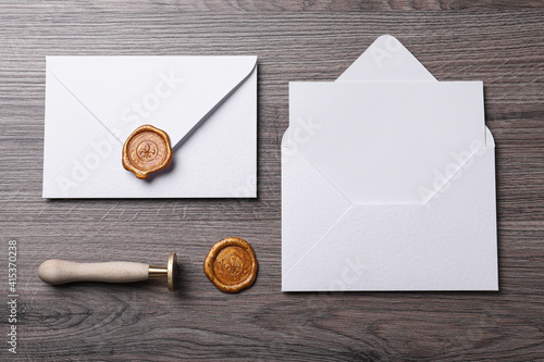 Картината върху платно Envelopes with wax seal and stamp on wooden table, flat lay