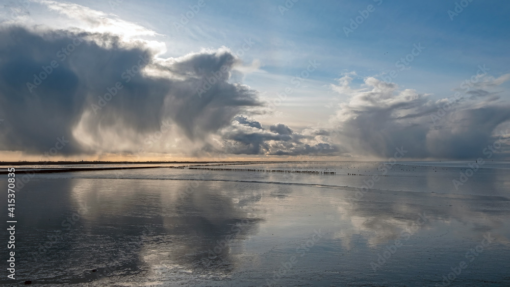 Incredible cloudscape at the Wadden sea near Holwerd in the Netherlands at sunset