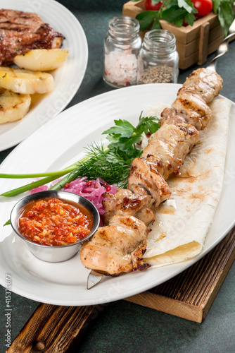 Chicken kebab with sauce and flatbread close-up