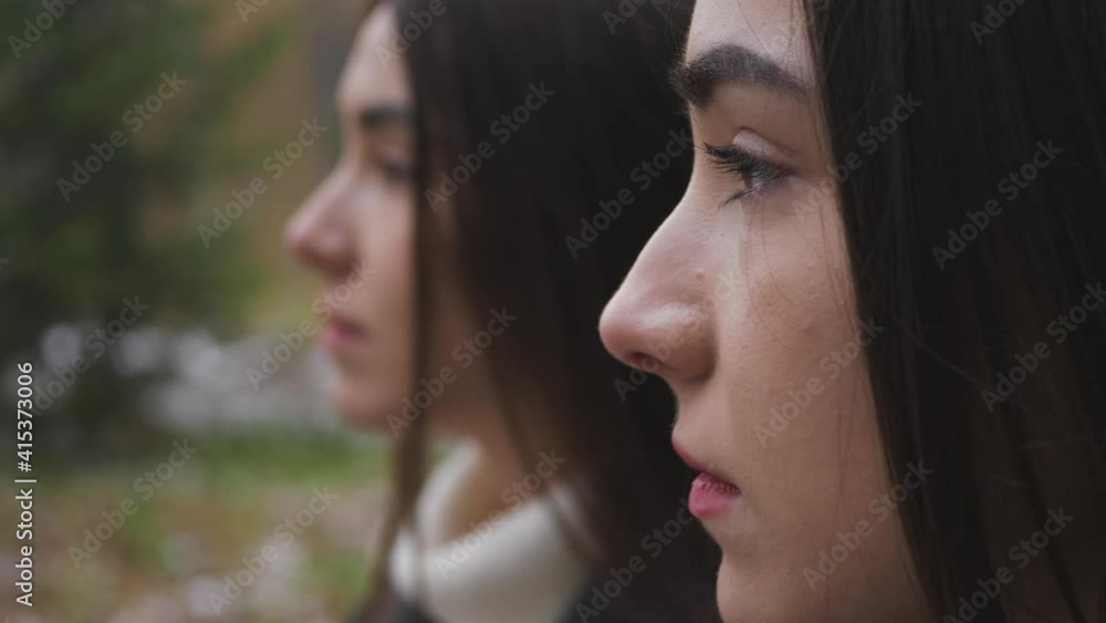 Outdoor portrait of Two Serious Twin Sisters' Profile Outdoor portrait of Two Serious Twin Sisters' Profile