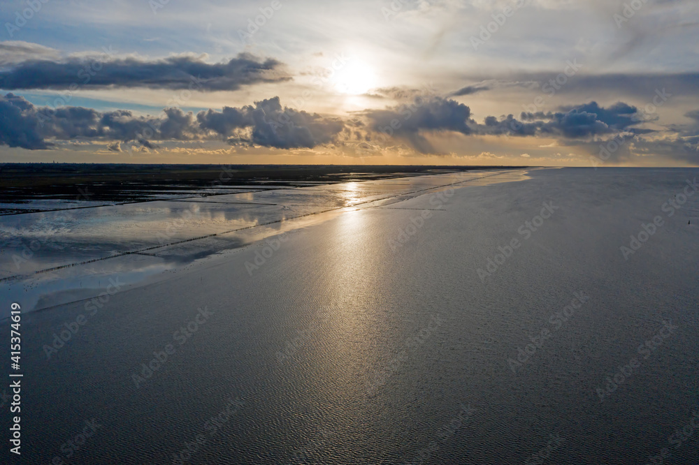 Aerial from the coast line at the Wadden Sea near Holwerd in the Netherlands at sunset