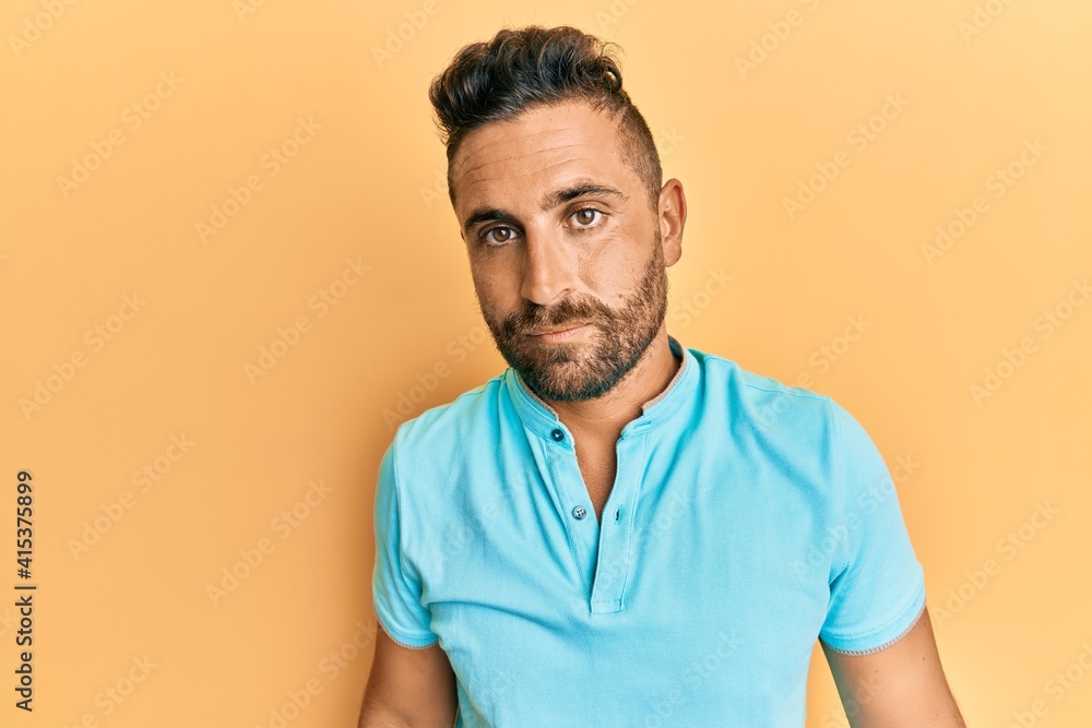 Handsome man with beard wearing casual clothes with serious expression on face. simple and natural looking at the camera. Handsome man with beard wearing casual clothes with serious expression on face. simple and natural looking at the camera.