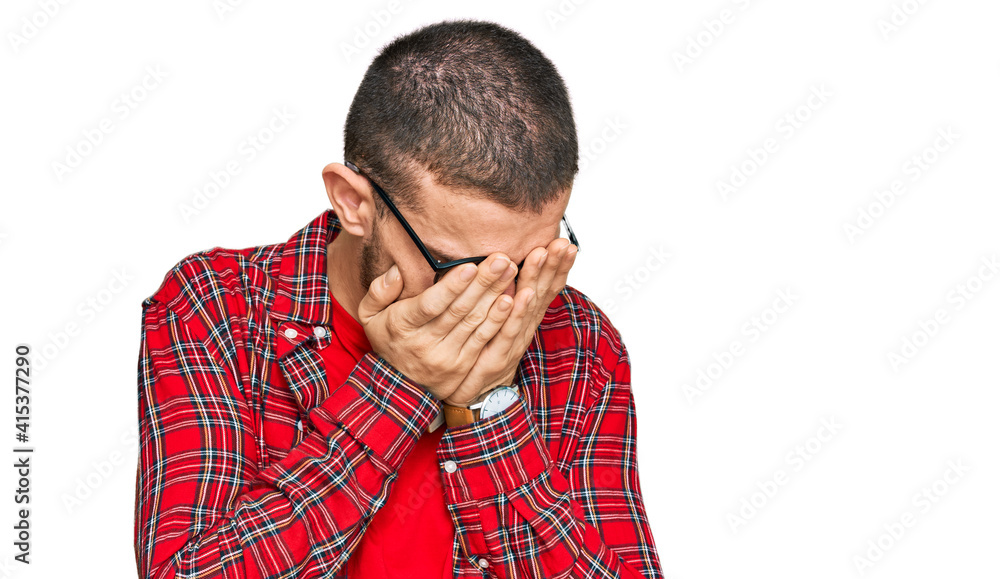 Hispanic young man wearing casual clothes with sad expression covering face with hands while crying. depression concept. Hispanic young man wearing casual clothes with sad expression covering face with hands while crying. depression concept.