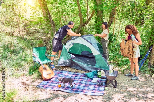 Family of hiker setting up the tent to camping at the forest