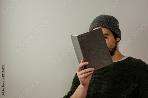 man covering his face with a gray task book