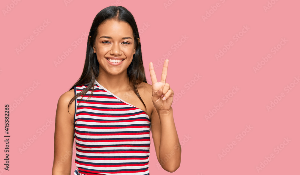 Beautiful hispanic woman wearing casual clothes showing and pointing up with fingers number two while smiling confident and happy. Beautiful hispanic woman wearing casual clothes showing and pointing up with fingers number two while smiling confident and happy.