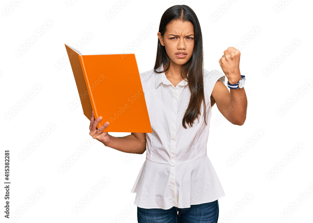 Beautiful hispanic woman reading book annoyed and frustrated shouting with anger, yelling crazy with anger and hand raised Beautiful hispanic woman reading book annoyed and frustrated shouting with anger, yelling crazy with anger and hand raised
