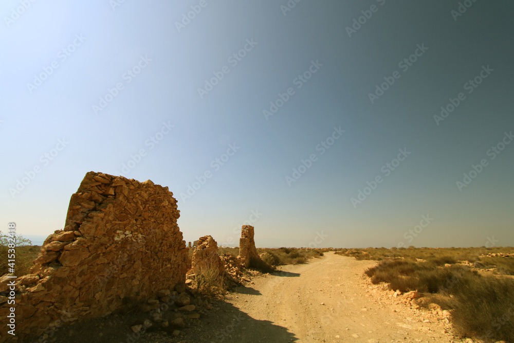 Camino atravesando zona árida con restos de antiguos edificios. Mazarrón (Murcia-España).