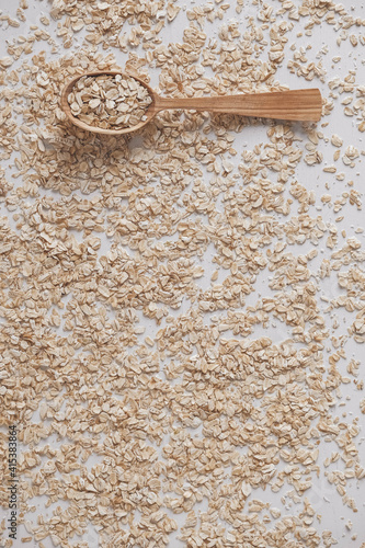 Uncooked oatmeal in a wooden spoon on a white background. Top view. Copy, empty space for text © Andriy
