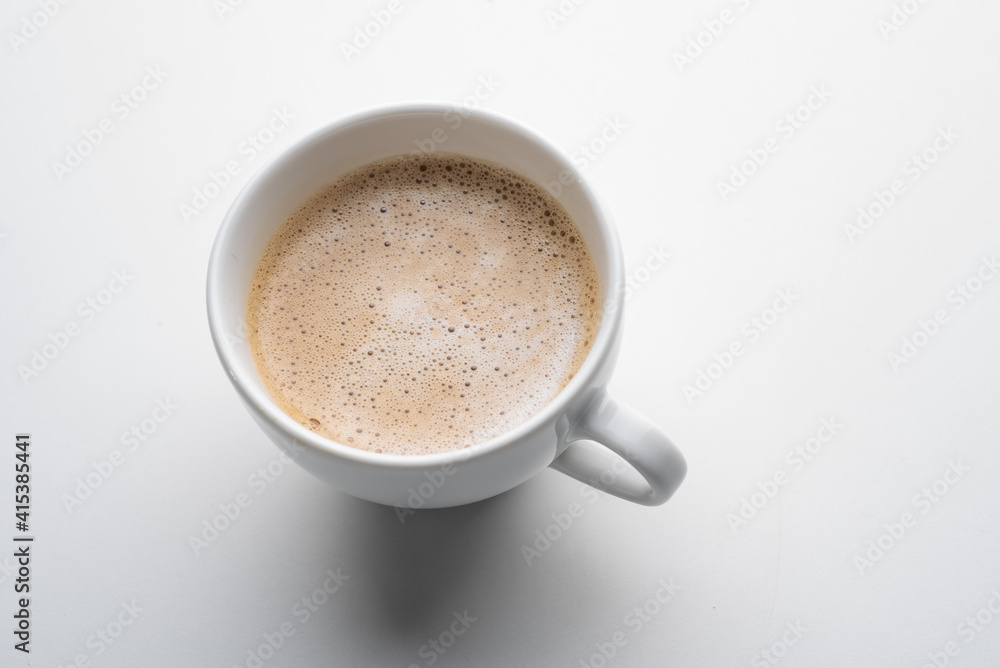 White cup of coffee in soft light isolated on a white background. Cappuccino coffee. White cup of coffee in soft light isolated on a white background. Cappuccino coffee.