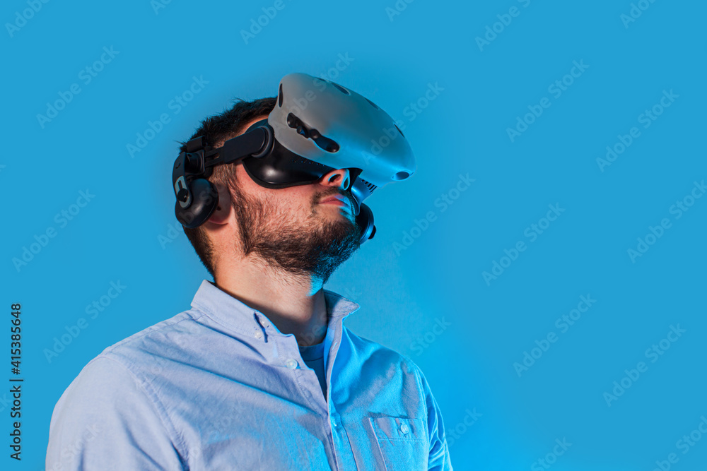 Young man using the virtual reality glasses and two gamepad Young man using the virtual reality glasses and two gamepad