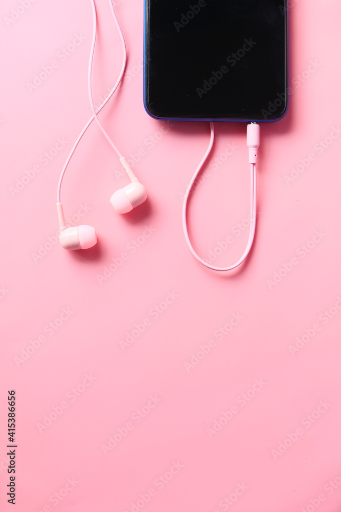 smart phone and headphone on pink background . smart phone and headphone on pink background .