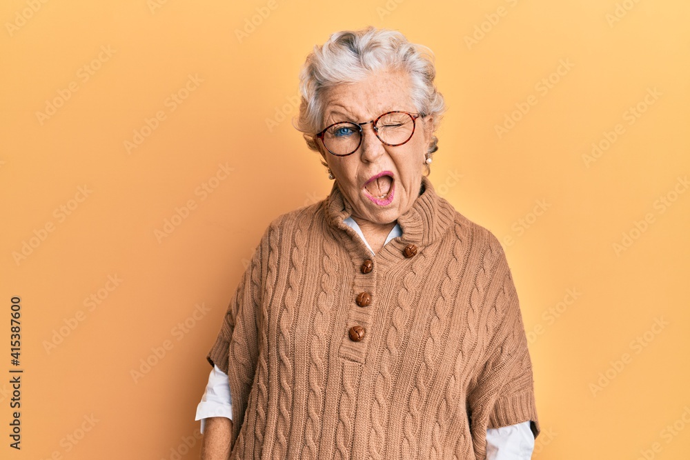 Senior grey-haired woman wearing casual clothes and glasses winking looking at the camera with sexy expression, cheerful and happy face. - obrazy, fototapety, plakaty 