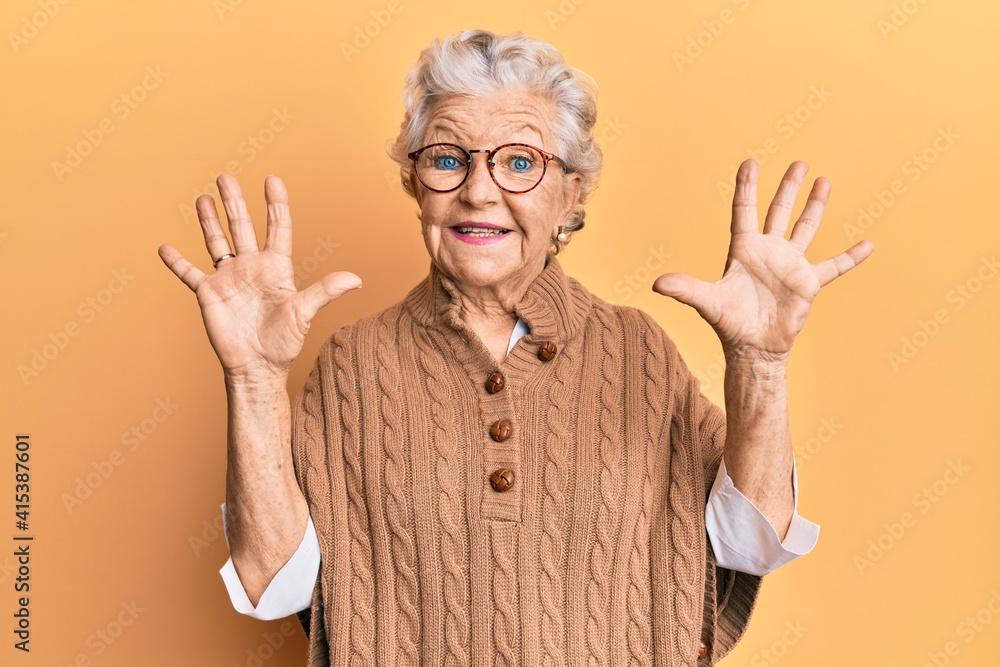Senior grey-haired woman wearing casual clothes and glasses showing and pointing up with fingers number ten while smiling confident and happy. Senior grey-haired woman wearing casual clothes and glasses showing and pointing up with fingers number ten while smiling confident and happy.