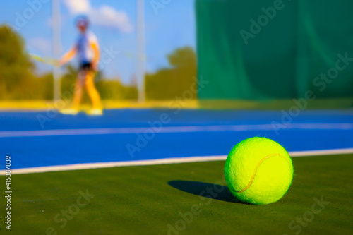 Tennis ball on the blue court