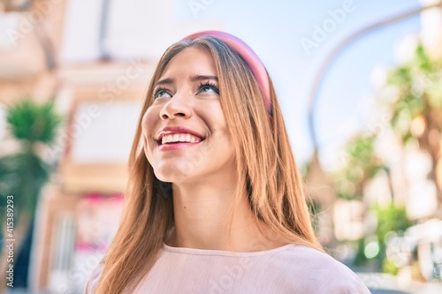 Young caucasian girl smiling happy walking at the city.