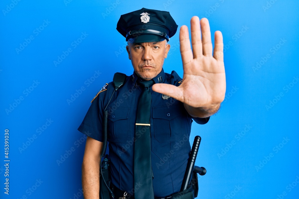Handsome middle age mature man wearing police uniform doing stop sing with palm of the hand. warning expression with negative and serious gesture on the face. Handsome middle age mature man wearing police uniform doing stop sing with palm of the hand. warning expression with negative and serious gesture on the face.