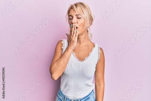 Young blonde girl wearing casual clothes bored yawning tired covering mouth with hand. restless and sleepiness.