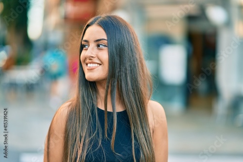 Young hispanic girl smiling happy standing at the city.