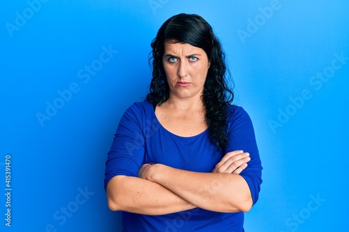 Plus size brunette woman wearing casual blue shirt skeptic and nervous, disapproving expression on face with crossed arms. negative person. © Krakenimages.com