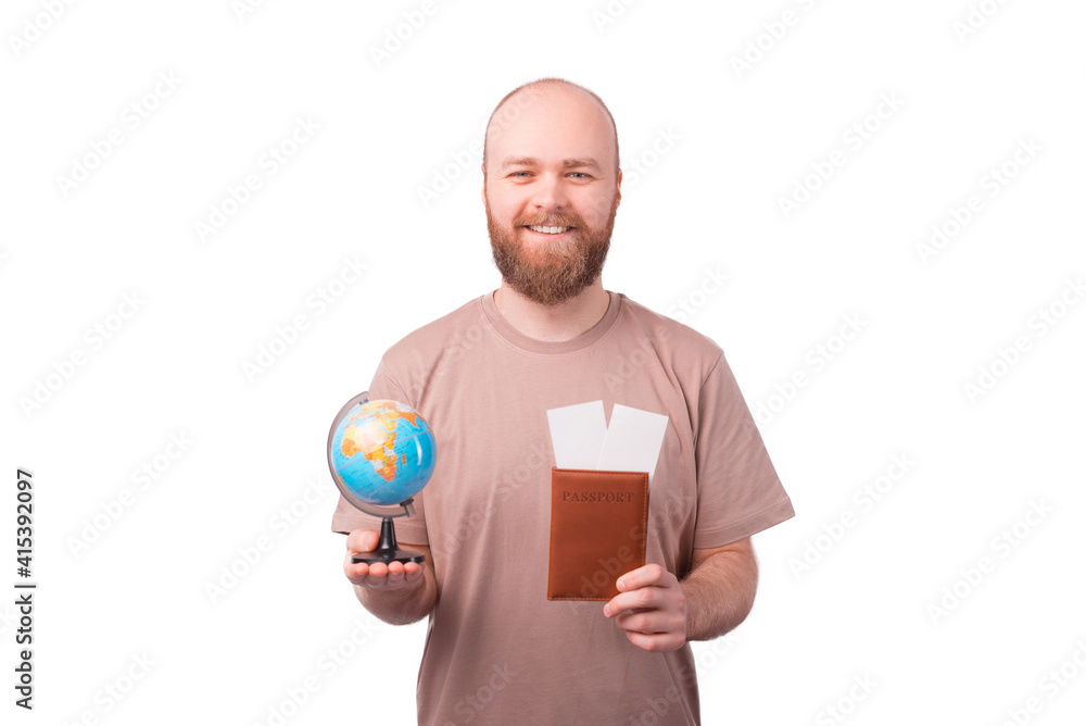 Cheerful young man holding passport and globe with airplane tickets, lets travel the world Cheerful young man holding passport and globe with airplane tickets, lets travel the world