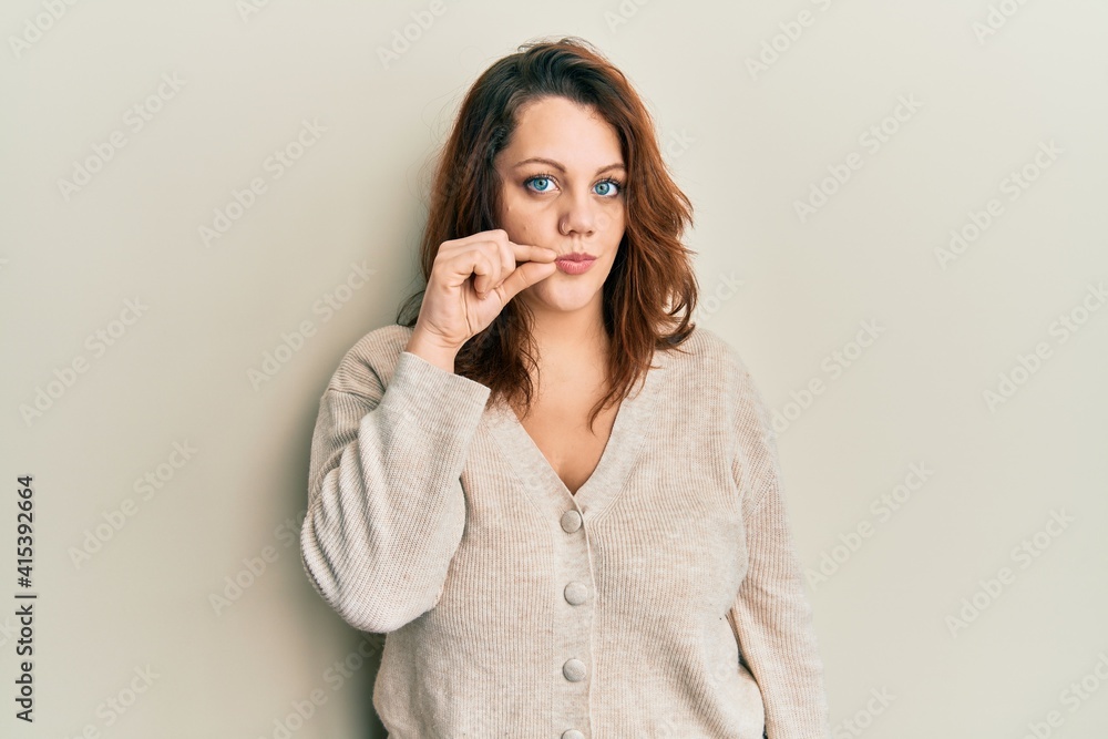 Young caucasian woman wearing casual clothes mouth and lips shut as zip with fingers. secret and silent, taboo talking Young caucasian woman wearing casual clothes mouth and lips shut as zip with fingers. secret and silent, taboo talking