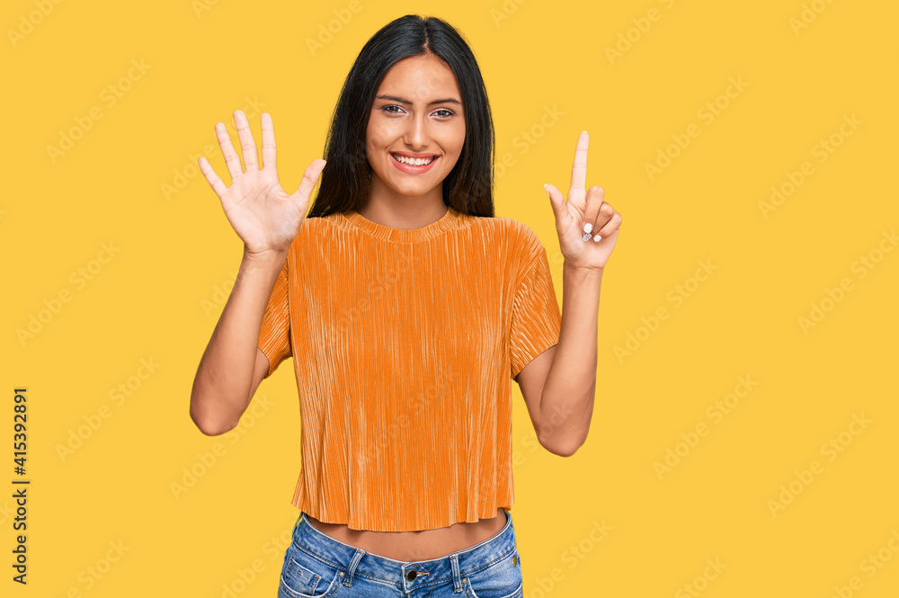 Young brunette arab woman wearing casual clothes showing and pointing up with fingers number seven while smiling confident and happy. Young brunette arab woman wearing casual clothes showing and pointing up with fingers number seven while smiling confident and happy.