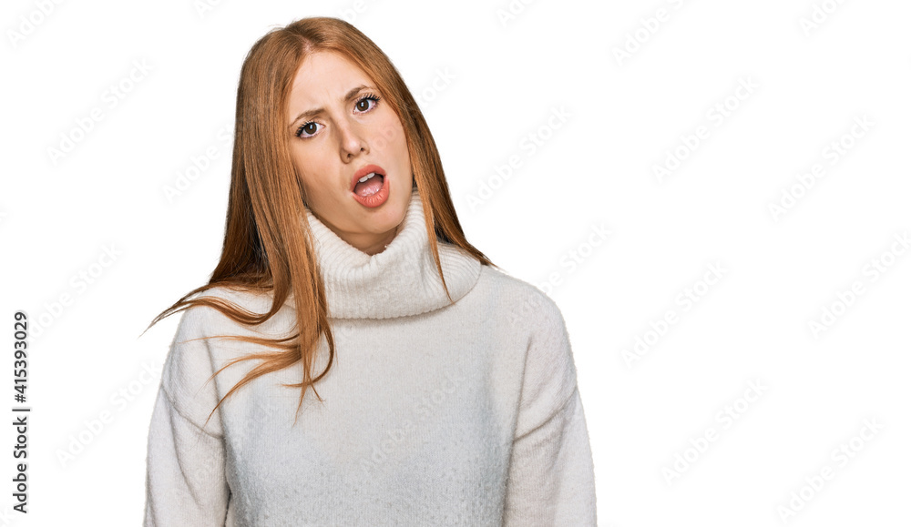 Young irish woman wearing casual winter sweater in shock face, looking skeptical and sarcastic, surprised with open mouth Young irish woman wearing casual winter sweater in shock face, looking skeptical and sarcastic, surprised with open mouth